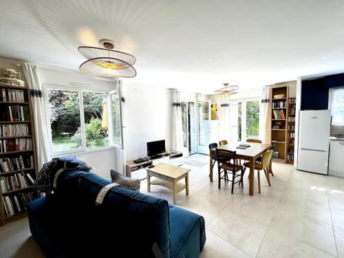 un salon avec un canapé bleu et une table dans l'établissement Harmonie - Agréable maison située dans un écrin de verdure, à La Tremblade