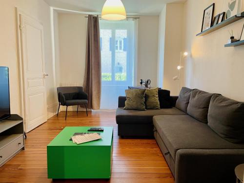 a living room with a couch and a table at Appartement avec place de parking et box vélos in Montbéliard