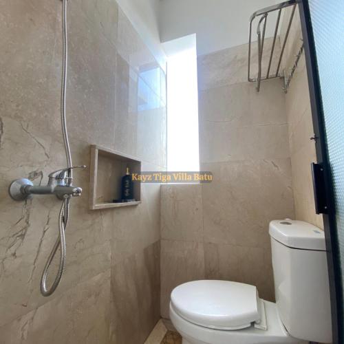 a bathroom with a shower with a toilet and a window at Kayz Tiga Villa Batu Private Pool Aesthetic in Tlekung