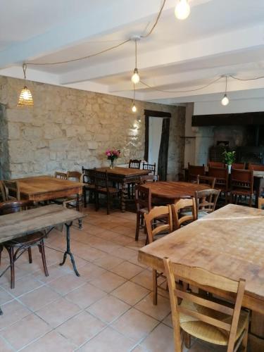 un restaurant avec des tables et des chaises en bois dans l'établissement La CELINA, à Saint-Étienne-de-Serres
