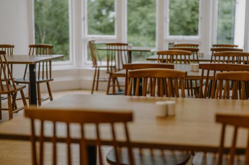 a room filled with tables and chairs and windows at Rowardennan Youth Hostel in Rowardennan
