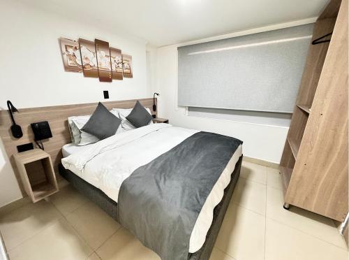 a bedroom with a large bed and a large screen at Hotel Fénix Real Bogotá in Bogotá