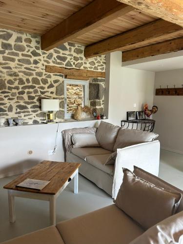 un salon avec un canapé et une table dans l'établissement Moulin de Joumard, Gîte de charme 4 personnes LE VANNOIR, à Aubazat