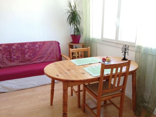 une table et des chaises en bois dans une chambre avec un canapé dans l'établissement Bright central apartment close to St Charles station, à Marseille