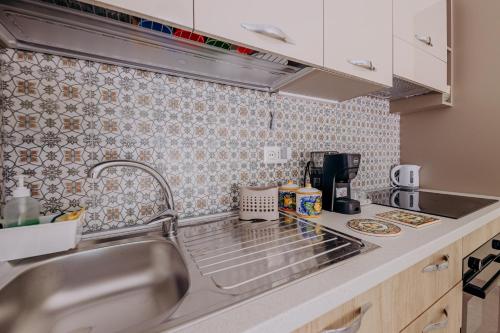 a kitchen with a sink and a counter top at Casa Zefiro Fontane Bianche in Fontane Bianche