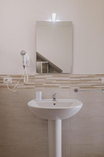a bathroom with a sink and a mirror at Casa Zefiro Fontane Bianche in Fontane Bianche