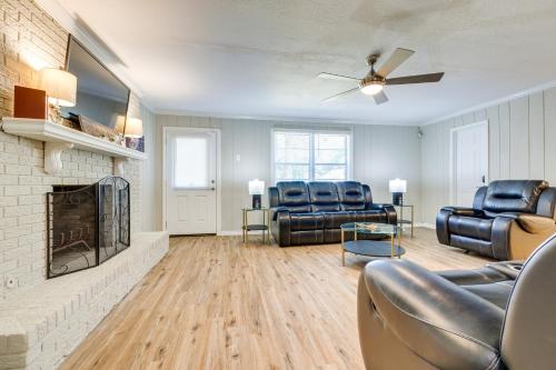a living room with leather furniture and a fireplace at Charming Gulfport Home about 2 Mi to Marina in Gulfport