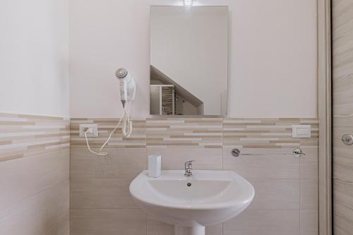 a white bathroom with a sink and a shower at Casa Zefiro Fontane Bianche in Fontane Bianche