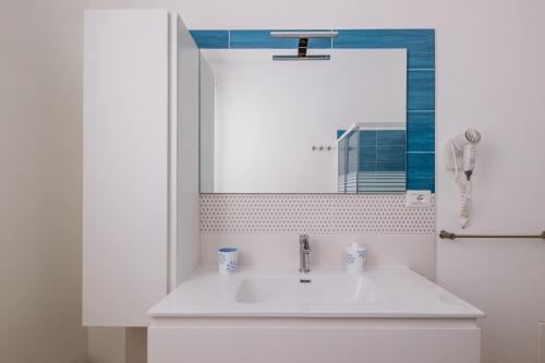 a bathroom with a sink and a mirror at Casa Zefiro Fontane Bianche in Fontane Bianche