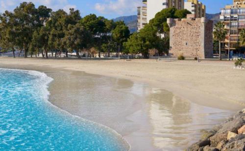 a beach with buildings and trees and the ocean at Nuevo Apartamento Moderno en Benicasim con Terraza y a Minutos de la Playa in Benicàssim