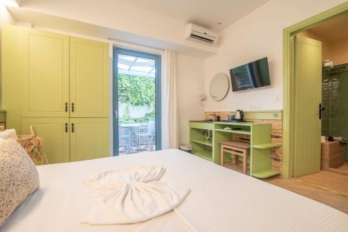 a bedroom with a bed and a desk and a television at Saronis Hotel Agistri - Adults Only in Skala