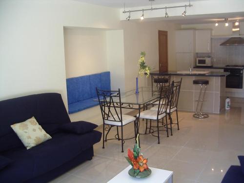 un salon avec une table et des chaises et une cuisine dans l'établissement Résidence du parc, à Souillac