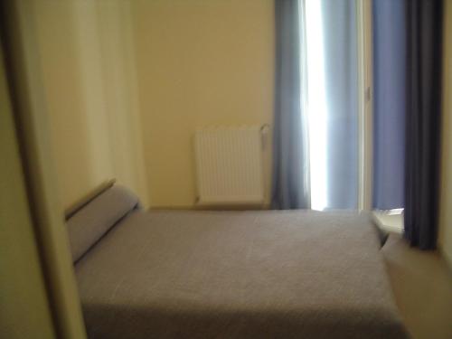 une petite chambre avec un lit et une fenêtre dans l'établissement Résidence du parc, à Souillac