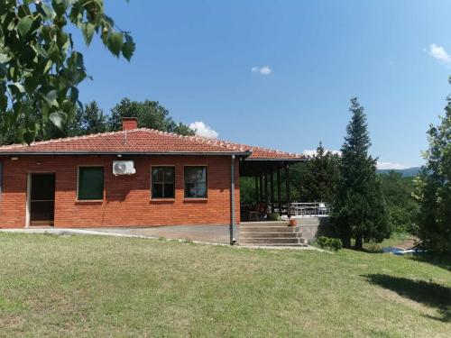 a house with a large yard in front of it at Cottage House Official in Niš