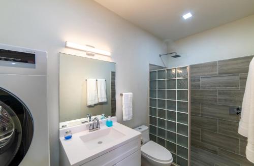 a bathroom with a sink and a toilet and a mirror at Melrose House Dominica in Roseau