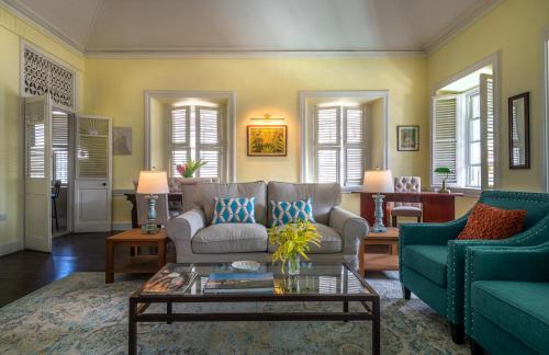 a living room with a couch and a table at Melrose House Dominica in Roseau