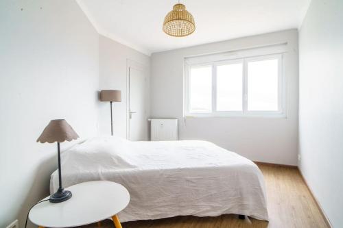 - une chambre blanche avec un lit, une table et une fenêtre dans l'établissement Appartement avec vue hypercentre, à Toulouse