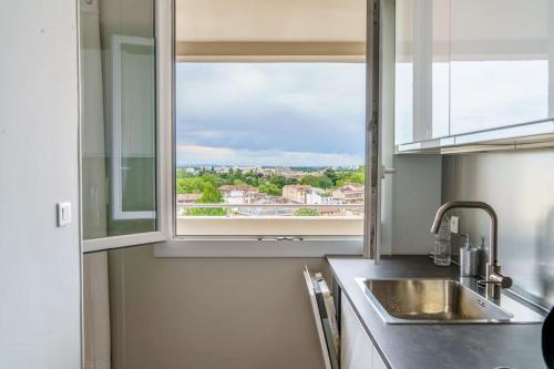 une cuisine avec un évier et une fenêtre dans l'établissement Appartement avec vue hypercentre, à Toulouse