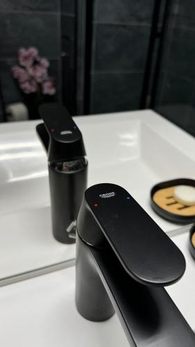 deux dispositifs noirs assis sur une table blanche dans l'établissement Apt Juan-les-Pins Clim-Plage 200m -Piscine, à Antibes