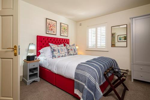 a bed with a red headboard in a bedroom at Cary Arms & Spa in Torquay