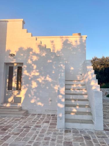 a shadow of a tree on the side of a building at Casalento in Ceglie Messapica