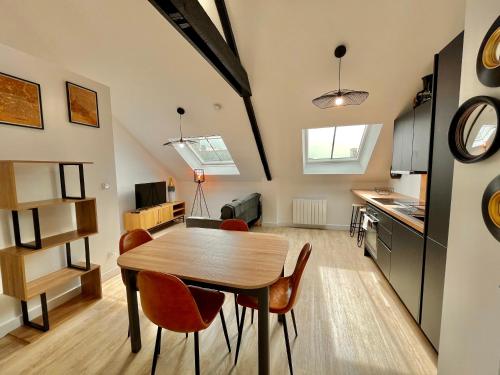 une cuisine et une salle à manger avec une table et des chaises dans l'établissement LE VICTOR HUGO, à Cancale