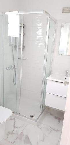 a white bathroom with a shower and a sink at EROS Maisonette in Latchi area just 700 meters or one-minute drive from Polis Municipal Beach in Lachi
