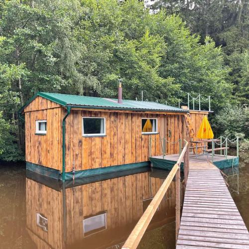 a house on the water next to a dock at Houseboat U Vodníka in Krásná Hora