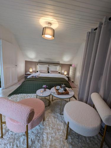 - une chambre avec un lit, 2 tables et des chaises dans l'établissement La Petite Maison de Locarn, à Locarn