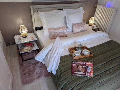 a hotel room with a bed with a magazine on it at La Petite Maison de Locarn in Locarn