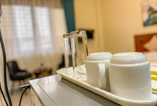 a tray with three cups on a table at iKHAYA RESIDENCES MUNYONYO in Kampala