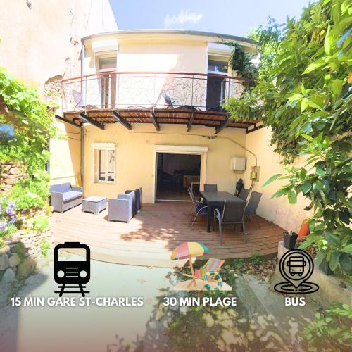 a house with a deck with a table and chairs at Grand Loft Lumineux - Gare St Charles 10 MIN in Marseille