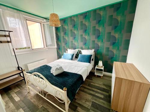 - une chambre avec un lit aux murs bleus et verts dans l'établissement appartement Pickup, à Caen