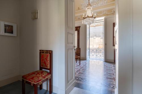 a hallway with a chair and a chandelier at Donna Zaira rooms&suites in Maglie