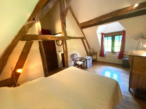 une chambre avec un lit blanc dans un grenier dans l'établissement Le Manoir de la Lanterne et son cottage - 2 à 9 pers, à Neuville-sur-Touques