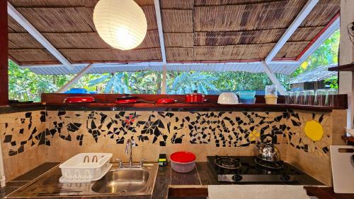une cuisine avec un évier, une cuisinière et une fenêtre dans l'établissement Cuarto Sol - Casa Oropopo, à Cocles