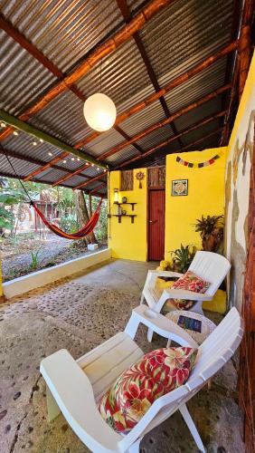a room with two beds and a hammock in it at Cuarto Sol - Casa Oropopo in Cocles