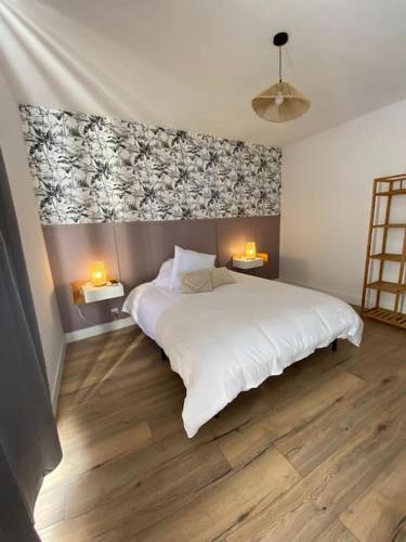 a bedroom with a large white bed with two lamps at Maison de groupe en Bourgogne L antre amis in Molesmes