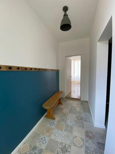 a hallway with a bench and a blue wall at Maison de groupe en Bourgogne L antre amis in Molesmes