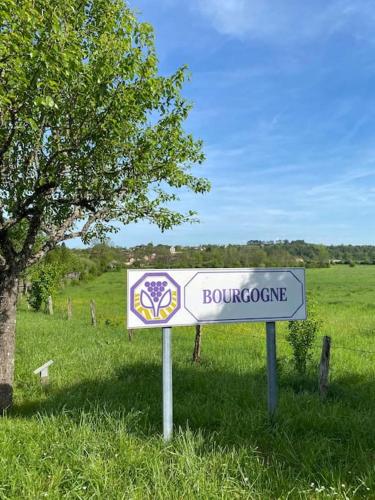 a sign in the grass next to a field at Maison de groupe en Bourgogne L antre amis in Molesmes