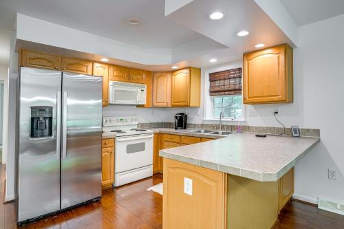 a kitchen with wooden cabinets and a stainless steel refrigerator at Spacious Virginia Retreat with Dock and Beach Access! in Bumpass