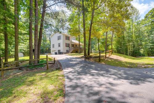 a driveway leading to a white house in the woods at Spacious Virginia Retreat with Dock and Beach Access! in Bumpass