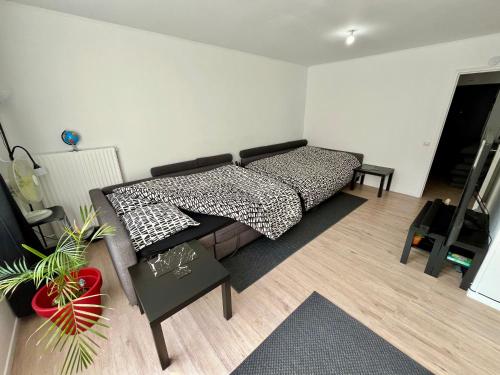 une chambre avec un lit et un salon dans l'établissement Decathlon Arena Stade Pierre Mauroy à 5mn à Pieds, à Villeneuve d'Ascq