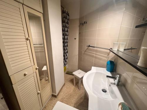 une salle de bain avec un lavabo blanc et des toilettes dans l'établissement Appartement Port Royal, au Grau-du-Roi