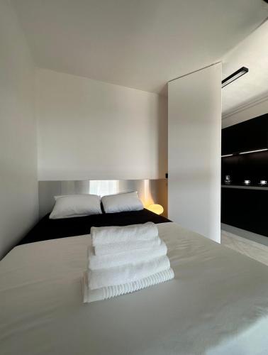 une chambre avec un lit avec des serviettes blanches dessus dans l'établissement Appartement Design élégant, au Cannet