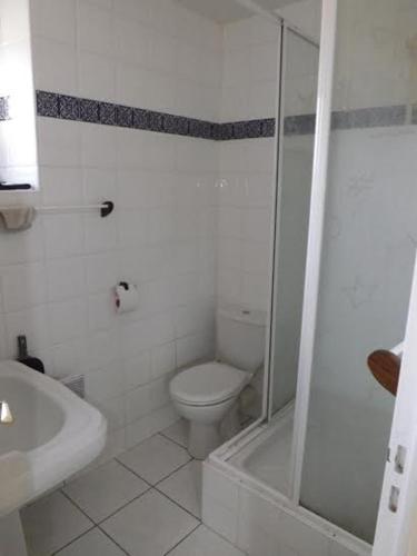 une salle de bain blanche avec toilettes et douche dans l'établissement Une halte entre terre et mer, à Ploemel