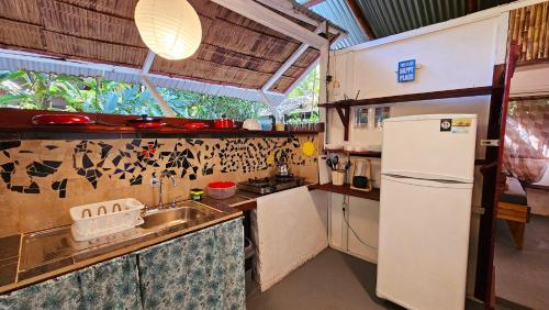 a small kitchen with a refrigerator and a sink at Cuarto Luna - Casa Oropopo in Cocles
