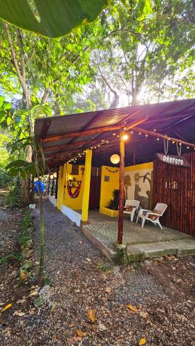 a building with a purple roof with two chairs under it at Cuarto Luna - Casa Oropopo in Cocles