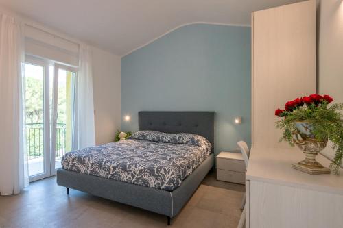 a bedroom with a bed and a vase of flowers on a table at Costabella Rooms in Deiva Marina
