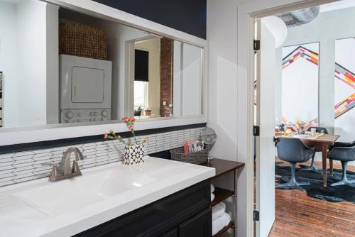 un baño con lavabo y espejo en High-design Downtown Loft, en Asheville